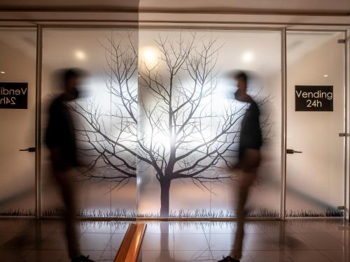 two people walking past a tree in a building at Sancho Ramirez in Pamplona