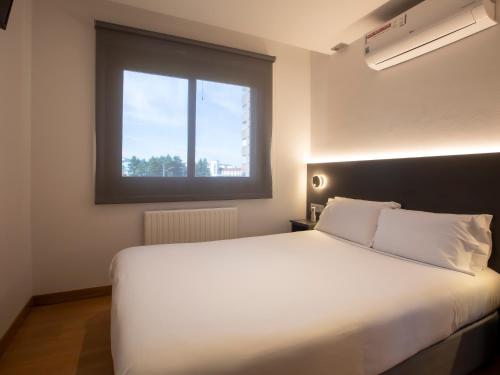 a bedroom with a large white bed with a window at Sancho Ramirez in Pamplona