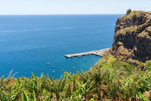 eine Brücke über einen Wasserkörper neben einer Klippe in der Unterkunft Sonho do Oceano in Ribeira Brava