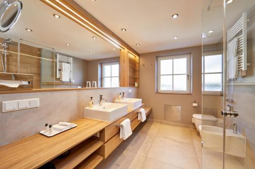 a bathroom with a sink and a toilet and a mirror at Hotel Zugspitze in Garmisch-Partenkirchen