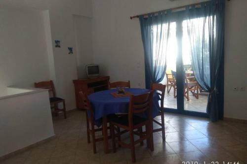 a dining room with a blue table and chairs at Blue Velvet apartment in Paránimfoi