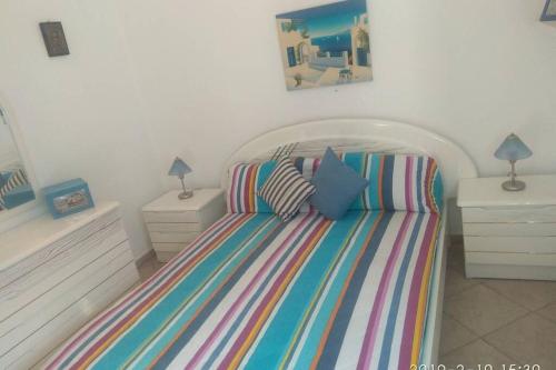 a bedroom with a striped bed with two night stands at Blue Velvet apartment in Paránimfoi