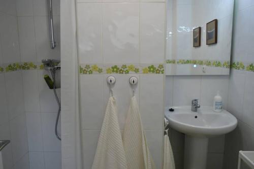 biała łazienka z umywalką i prysznicem w obiekcie Apartamento cerca de la playa w mieście Santander