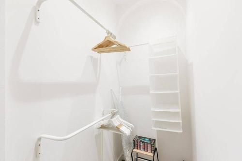 a white closet with white shelves in a room at ST MARYS APARTMENT - Modern Apartment in Charming Market Town in the Peak District in Penistone