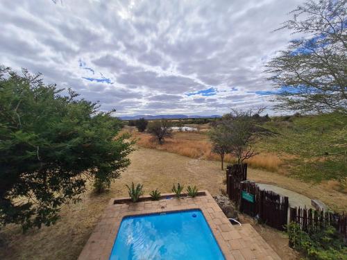 a swimming pool in the middle of a field at Zebula 5 Bedroom, sleeps12 IZN1 in Mabula
