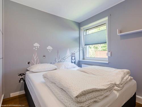 1 dormitorio con 1 cama con sábanas blancas y ventana en Kameralny Domek(jezioro, las, klimatyzacja, Wi-fi), en Czluchów