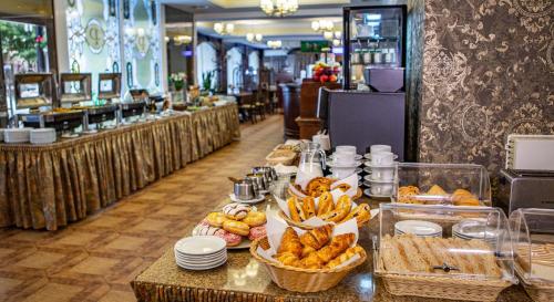 a buffet line with bread and pastries in a restaurant at Premier Hotel Palazzo in Poltava