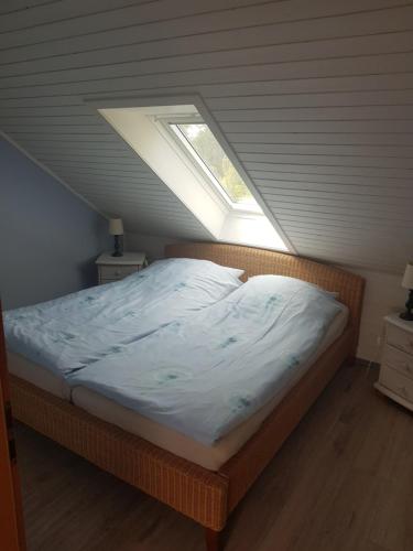 Bett in einem Zimmer mit Fenster in der Unterkunft Ferienwohnung 2 - Leopold in Cuxhaven