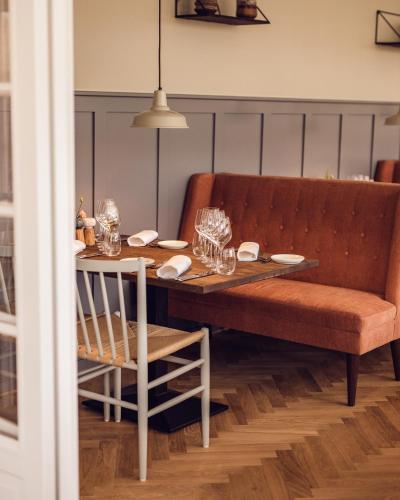 a dining room table with a couch and a table and chairs at Arnbjerg Pavillonen in Varde