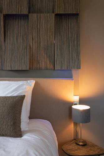 a bedroom with a white bed and a lamp at B & B De Elsterberg in Elst