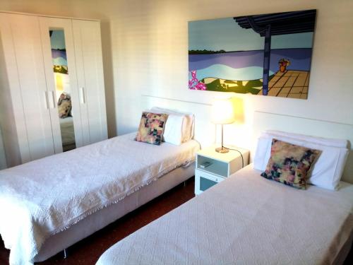 a bedroom with two beds and a lamp in it at Sera de Vall in San Antonio Bay
