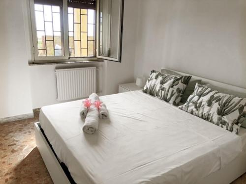a white bed with a stuffed animal on top of it at Seafront apartment 2 in Villa near Rome in Torvaianica