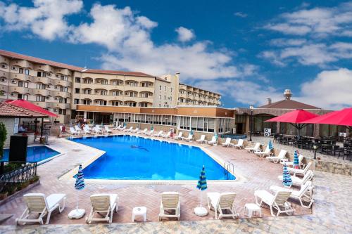 une piscine avec des chaises longues et un hôtel dans l'établissement SIGNATURE GARDEN AVANOS Hotel & SPA, à Avanos