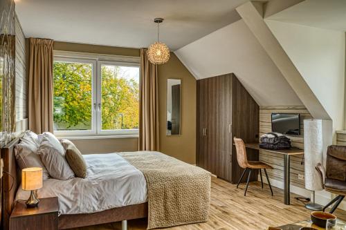 1 dormitorio con cama, escritorio y ventana en B & B De Elsterberg en Elst