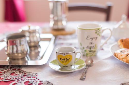 a table with two coffee cups and a plate of food at Traditional House Beranu Sardinia in Cala Gonone