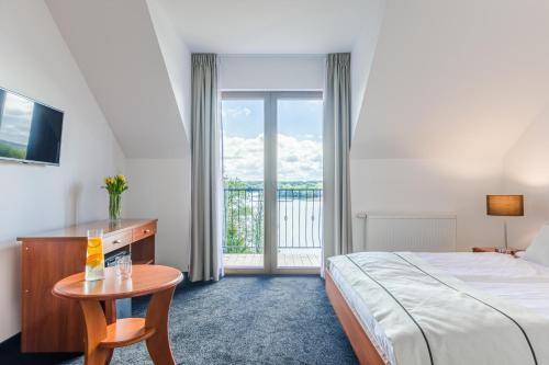 pokój hotelowy z łóżkiem, stołem i oknem w obiekcie Pensjonat Gieland koło Mrągowa w mieście Sorkwity
