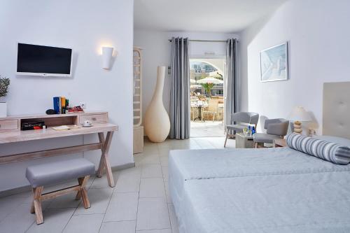 um quarto com uma cama, uma mesa e cadeiras em Aegean Plaza Hotel em Kamari