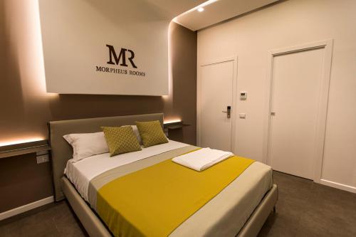 um quarto com uma cama com um cobertor amarelo em Morpheus Rooms em Nápoles
