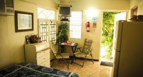 a bedroom with a desk and a table and a refrigerator at Casa Robinson Guest House in Culebra