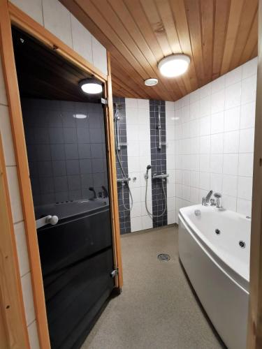 a bathroom with a shower and a tub and a sink at Huvikallio B in Syöte