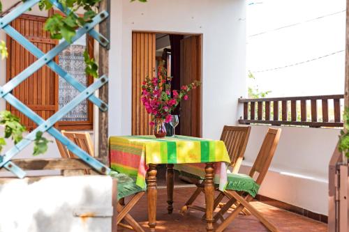 a table and chairs on a balcony with flowers on it at Traditional House Beranu Sardinia in Cala Gonone