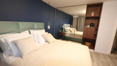 una camera con un letto bianco e una parete blu di Etal Luxury Rooms a Dubrovnik