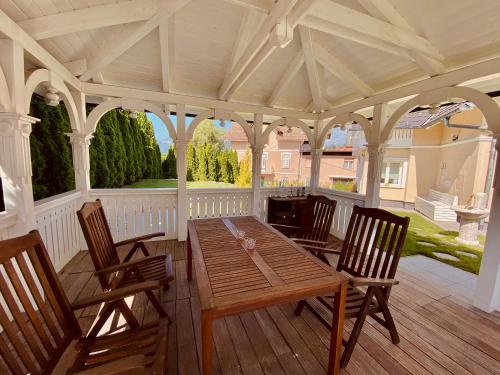 eine Veranda mit einem Holztisch und Stühlen in der Unterkunft Vacation House Vila Mia in Bled