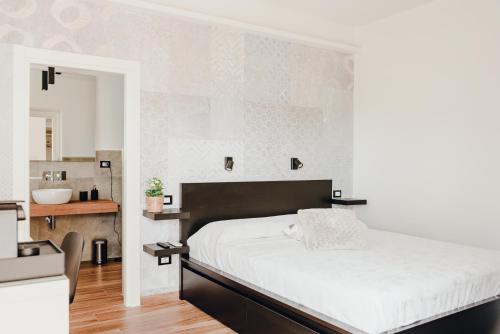 a bedroom with a large bed and a sink at Le Camere di Giò in Ameglia