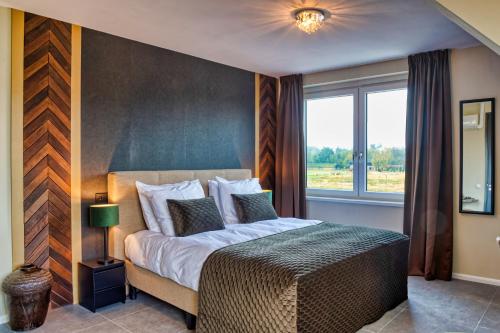 a bedroom with a large bed and a window at B & B De Elsterberg in Elst