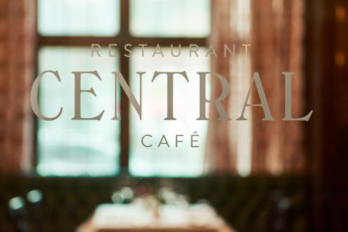 a sign for a restaurant central cafe in front of a table at Eden Hotel Wolff in Munich