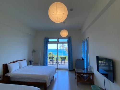 um quarto com 2 camas, uma televisão e uma janela em 春夏秋冬海景民宿Ocean View Motel em Chenggong