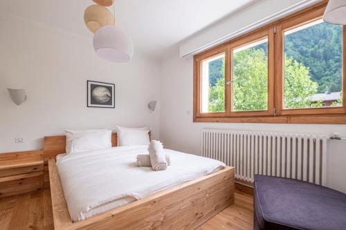 une chambre avec un grand lit et une fenêtre dans l'établissement Au Cœur du Glacier, à Chamonix-Mont-Blanc