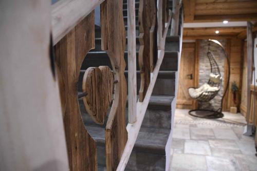 a spiral staircase in a wooden cabin with a statue at Hotel Mariandl - Singender Wirt in Haibach