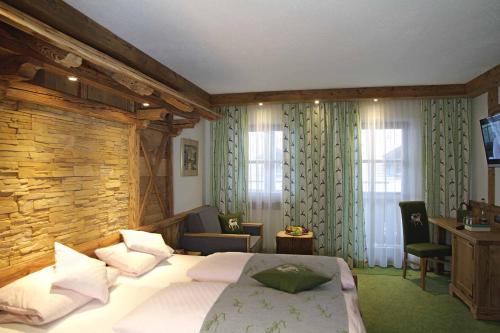 a bedroom with a bed and a stone wall at Hotel Mariandl - Singender Wirt in Haibach