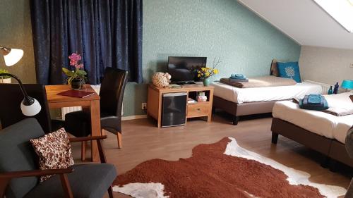 a living room with two beds and a tv at Boerderij Hazenveld in Kockengen