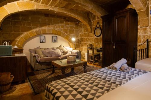 a living room with a couch and a table at The Burrow Guest House in Tarxien