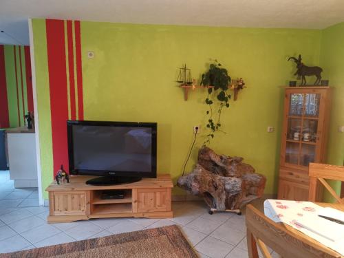 a living room with a television on a wooden entertainment center at Ferienwohnung im Landhausstil in Oberreute