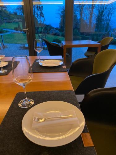 a table with a plate and wine glasses on it at Hotel Schlossberg in Badenweiler