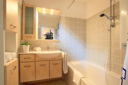 łazienka z umywalką i wanną w obiekcie Apartment Alpine by Apartment Managers w mieście Kirchberg in Tirol