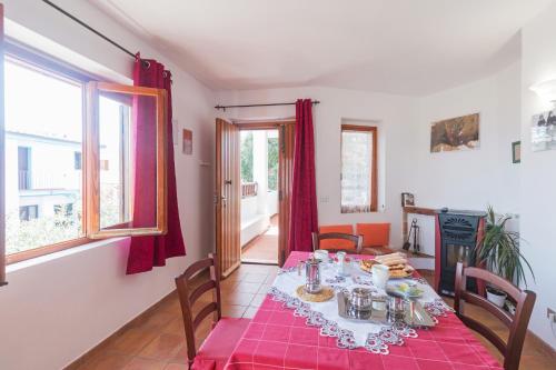 a dining room with a table with a red table cloth at Traditional House Beranu Sardinia in Cala Gonone