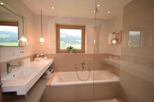 a bathroom with a tub and a sink and a shower at Apartment Brandstätter 1 & 2 by Apartment Managers in Brixen im Thale