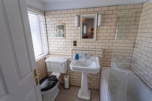 a bathroom with a sink and a toilet and a tub at The Smugglers Inn in Weymouth