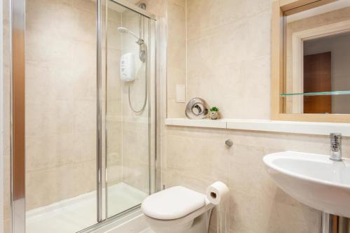 a bathroom with a shower and a toilet and a sink at Old Prestwick View - Donnini Apartments in Prestwick