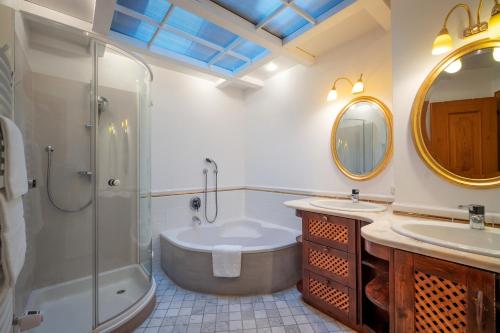 ein Bad mit einer Badewanne, einer Dusche und einem Waschbecken in der Unterkunft Chalet Gaisberg by Apartment Managers in Kirchberg in Tirol