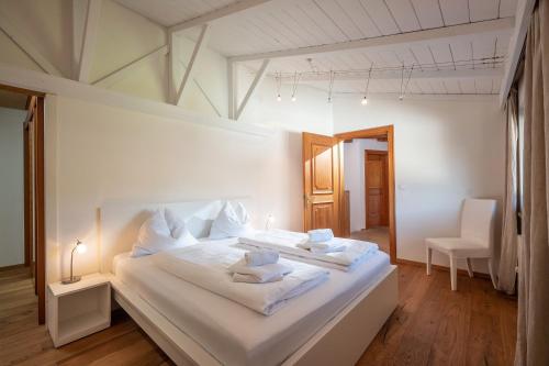 1 dormitorio con 1 cama blanca grande con almohadas blancas en Chalet Gaisberg by Apartment Managers en Kirchberg in Tirol