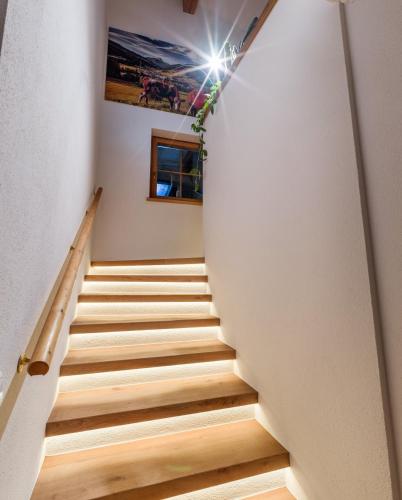a staircase in a house with white walls and wooden floors at Chalet Weinberg Top 1 & Top 2 by Apartment Managers in Kirchberg in Tirol