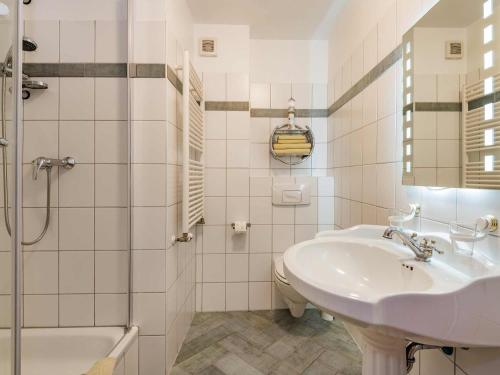 bagno bianco con lavandino e doccia di Aquarius Ferienwohnung Usedom a Loddin