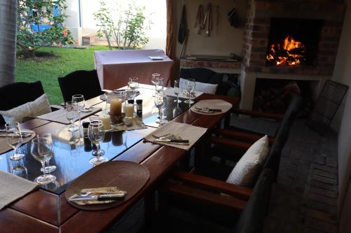 a table with wine glasses and a fireplace at 113 on Robberg in Plettenberg Bay
