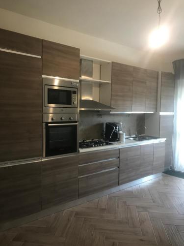 a kitchen with stainless steel appliances and wooden cabinets at Tindari guest house in Oliveri