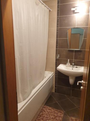 een badkamer met een bad, een wastafel en een douche bij Apartman Maxim Lux in Razlog